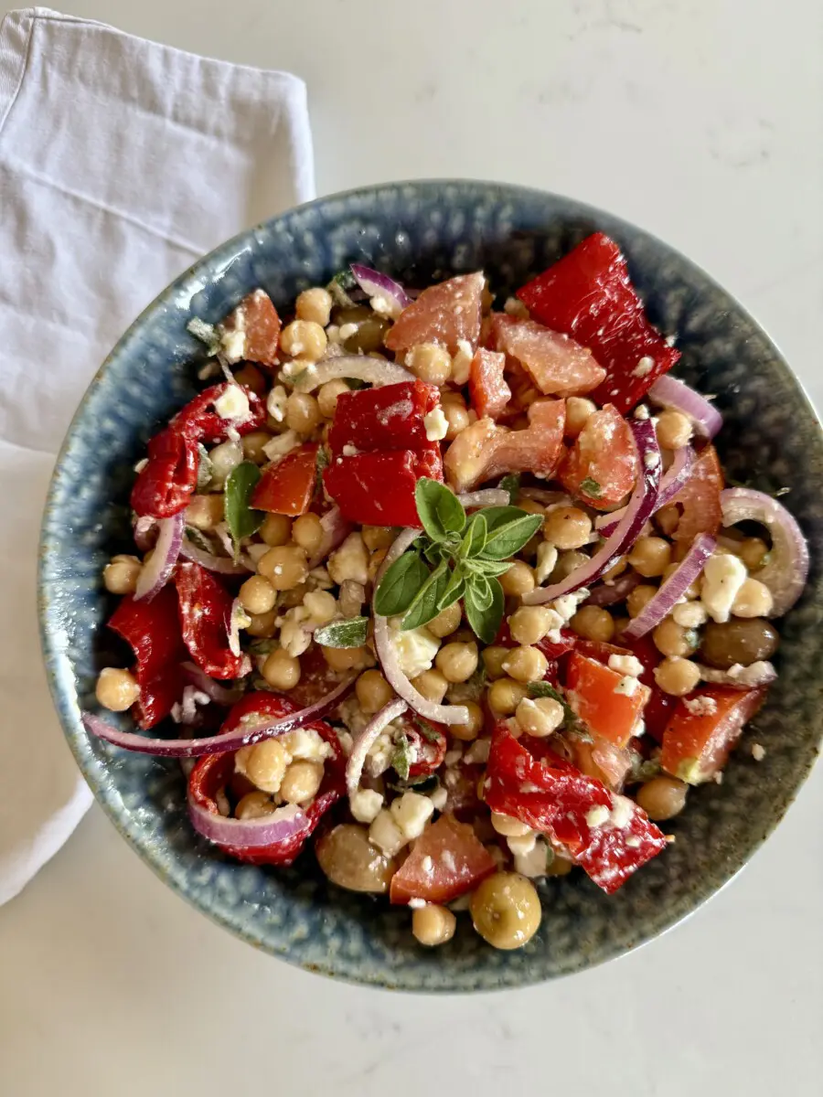 Mediterranean Chickpea Salad with Roasted Romano Peppers & FetaWash and prep the other vegetables and make the dressing. Whisk together olive oil, lemon juice, oregano, salt, and pepper. In a large bowl, combine everything: chickpeas, tomatoes, roasted peppers, olives, red onion. Drizzle with dressing and toss gently to combine. Crumble the feta cheese on the top. Let all to marinate for 10–15 minutes for best flavour. Equally nice chilled or served immediately.
